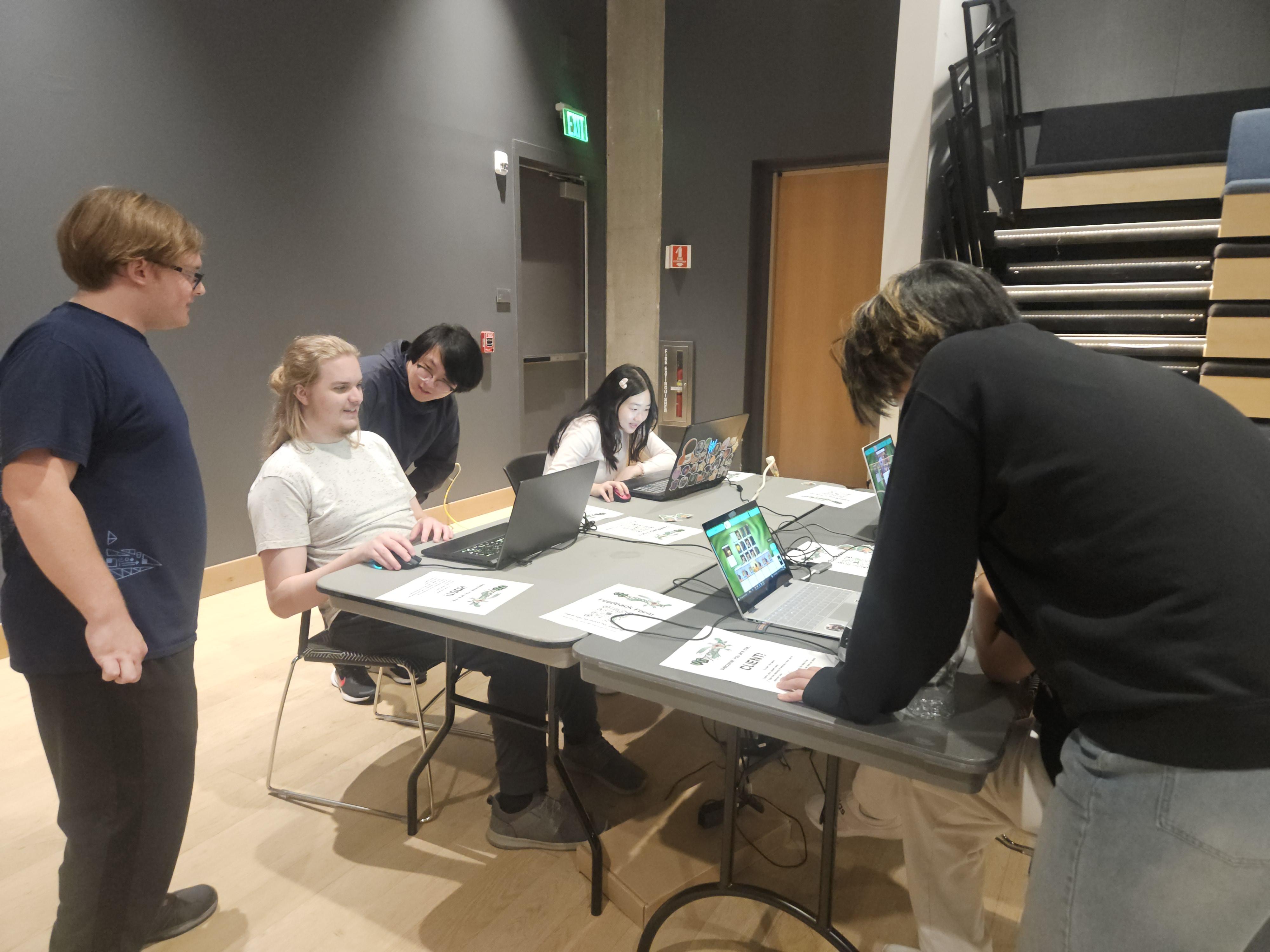 People standing around a table with laptops showcasing VGDimensions.